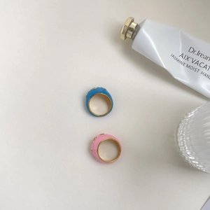 Détail de bagues en émail coloré avec bords dorés et accents de zircon blanc