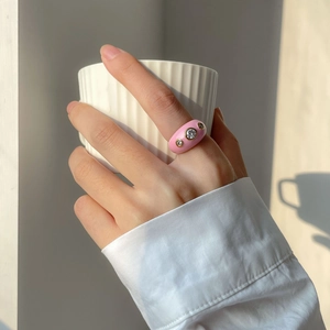 Bague bombée en émail rose avec trois zircons dans un cadre de vie élégant