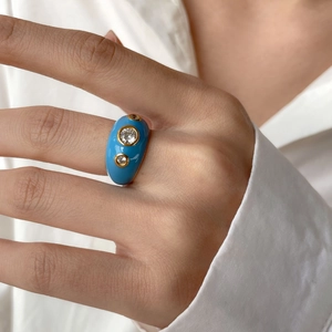 Bague large en émail bleu avec trois zircons ronds en finition dorée au doigt