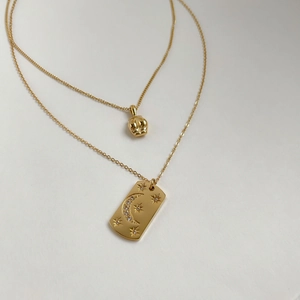 Détail de colliers vintage en titane doré avec pendentifs croissant de lune et étoile