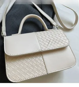 Detailed close-up of ivory crossbody bag featuring woven patchwork texture and soft material