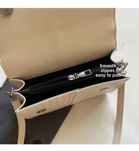 Detail view of smooth interior zipper pocket and cream woven texture leather bag