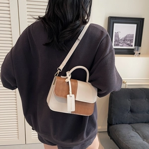 Chic quilted beige and brown crossbody bag with handle shown on a model outfit