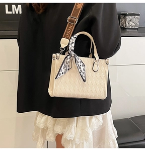 Detail of quilted tote bag with silk scarf handle and jacquard crossbody strap
