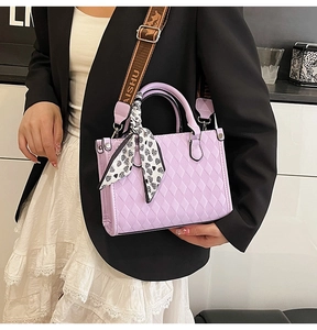 Close-up of lavender quilted tote bag with woven strap and decorative heart scarf