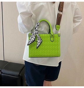 Detail of neon green quilted tote bag with silk scarf and logo printed shoulder strap