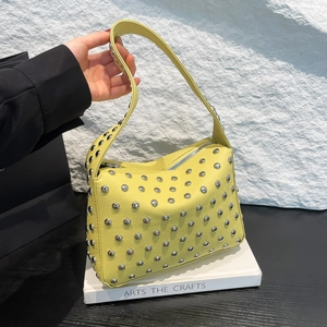 Yellow pebbled leather tote bag with silver studs and metal zipper closure for women