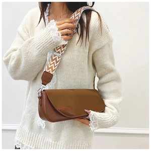 Close-up of brown PU crossbody bag featuring a unique wave pattern wide shoulder strap