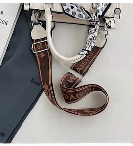 Detail of off-white quilted tote with adjustable logo strap and heart print silk scarf