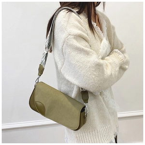 Close-up of olive green crossbody bag with textured matte finish and patterned strap
