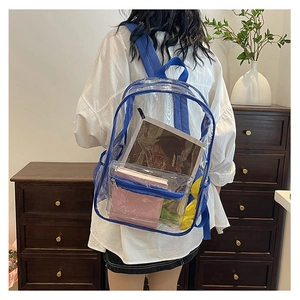 Detailed back view of a clear PVC backpack with blue trim worn in a cozy indoor setting
