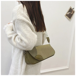 Olive green matte leather shoulder bag with geometric fabric strap shown on model