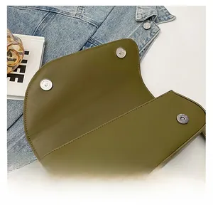 Detail of olive green shoulder bag showing secure magnetic snap closure and matte silver hardware