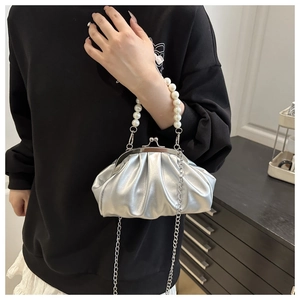 Detail of silver pleated cloud bag with large pearl handle and metal chain strap