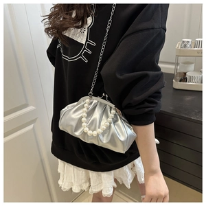 Detail of silver pleated cloud bag with pearl handle and metallic chain strap