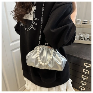 Silver metallic cloud bag with pearl chain and metal strap shown on a model