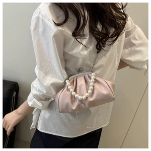 Detailed view of light pink pleated cloud bag with pearl handle and silver metal chain strap