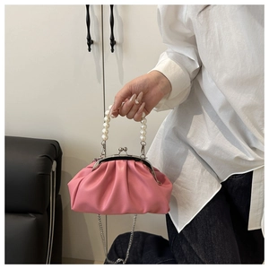 Detail of pink ruched cloud bag featuring pearl bead handle and vintage metal clasp