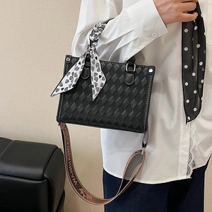 Large black quilted tote bag with silk scarf and patterned strap shown at 45-degree angle