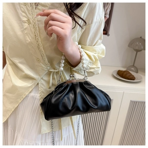 Detail of black pleated cloud bag with large pearl handle and silver chain strap