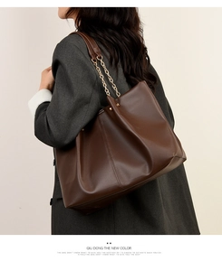 Dettaglio della borsa tote in morbida pelle PU marrone con elegante tracolla a catena oro