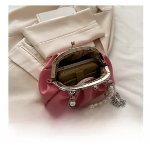 Pink pleated cloud bag with pearl handle showing interior capacity for phone and wallet