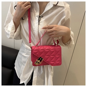 Detail of rose pink quilted crossbody bag with gold-tone lock and geometric texture