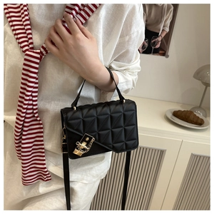 Close-up of elegant black quilted crossbody bag with gold buckle and stylish chain strap