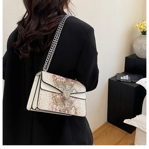Sac bandoulière à chaîne avec boucle serpent porté par un mannequin à l'épaule