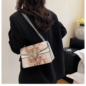 Détail du fermoir tête de serpent et cuir texturé sur sac bandoulière vintage à chaîne