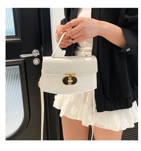 Close-up of stylish white leather small square bag with textured embossing and metal clasp