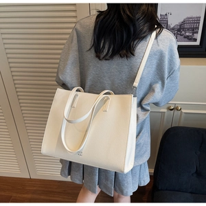 Dettaglio borsa tote in pelle bianca con tracolla rimovibile e logo del marchio