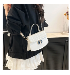 Model view of white crossbody bag with embossed flap and gold twist lock clasp