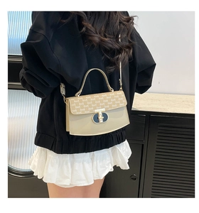 Detail of elegant beige crossbody bag showing metal clasp and vintage patterns