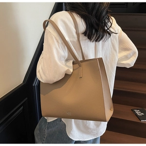Dettaglio della borsa tote in pelle kaki con grana litchi e logo inciso sul fondo