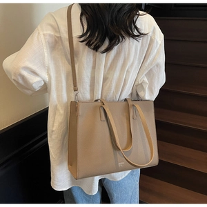 Borsa tote in pelle con motivo litchi indossata per mostrare dimensioni e dettagli
