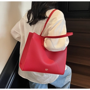 Dettaglio della borsa tote in pelle martellata rossa con logo MER PAI dorato e tracolla