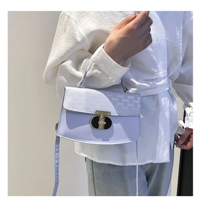 Detail of light purple shoulder bag with logo pattern and gold metallic lock buckle
