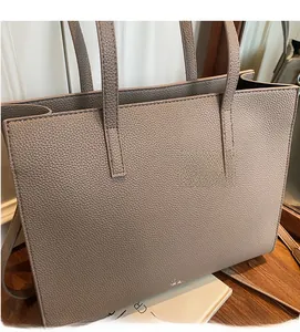 Dettaglio della borsa tote taupe con trama in pelle litchi e logo argentato