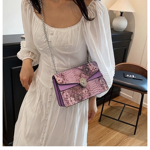 Détail du sac violet avec texture serpent, broderie et boucle tête de tigre argentée