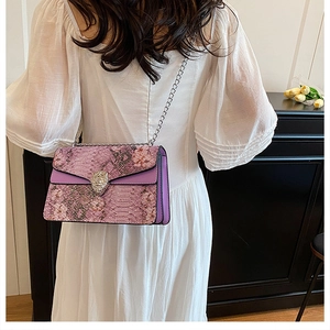 Vue détaillée du sac bandoulière violet en relief serpent avec boucle tête de lion en diamants
