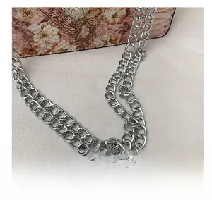 Détail du sac à fleurs roses avec boucle tête de lion argentée et chaîne métallique