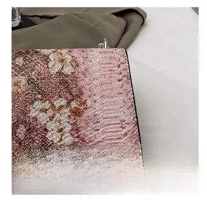 Détail macro du cuir gaufré serpent avec imprimé floral blanc et chaîne en argent
