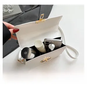 Detail view of white crossbody bag interior showing phone and cosmetics capacity
