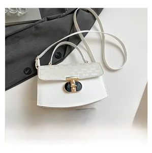 Close-up of white crossbody bag featuring gold T-lock and branded flap lettering