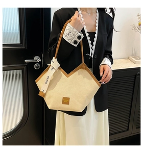 Detail of beige canvas tote with brown leather trim and decorative Chia'2nd ribbon