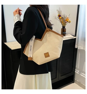 Detail of canvas tote bag with brown leather trim and decorative printed shoulder strap