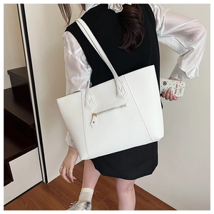Detail of the white pebble leather tote bag featuring a back zipper pocket and golden hardware