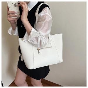 Close-up of white lychee grain leather tote bag with functional front zipper detail