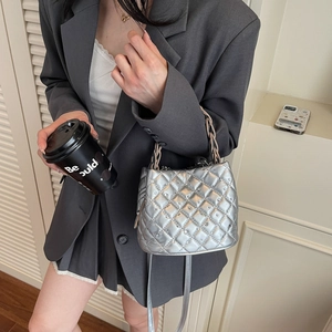Silver quilted bucket bag with rhinestones and gold chain handle shown by a model
